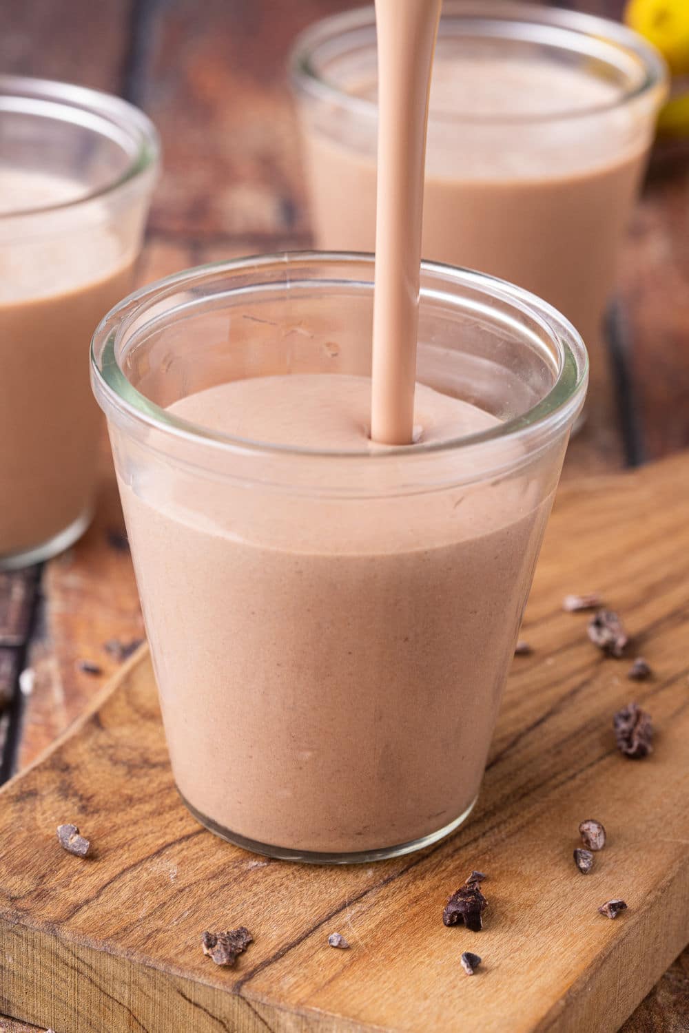 Pouring chocolate smoothie into a glass.