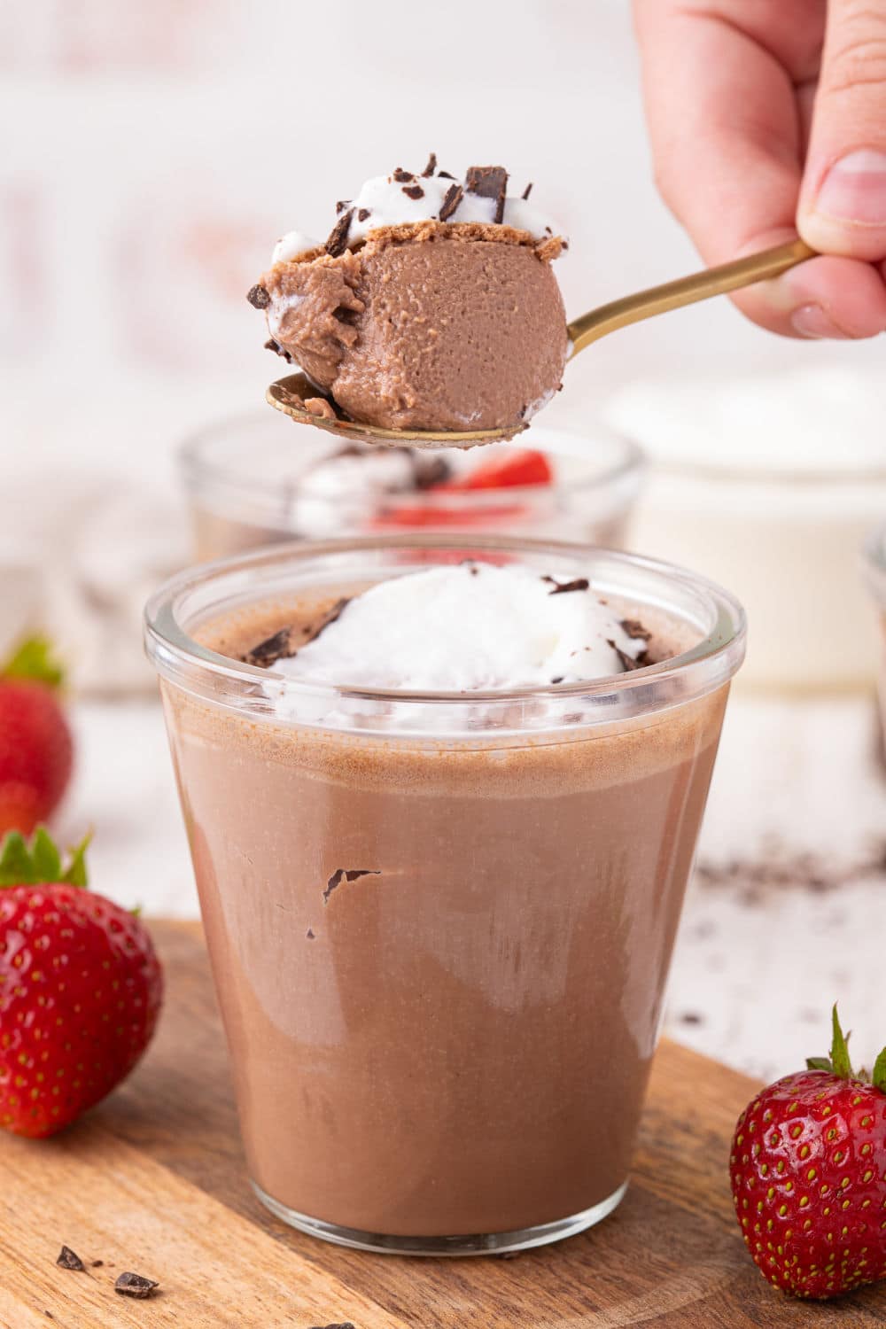 Spoonful of chocolate pudding with whipped cream.