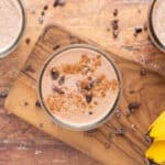 Chocolate smoothie in a glass topped with cinnamon and cacao nibs.