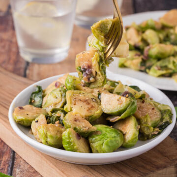 Fork in plate full of Brussels sprouts.