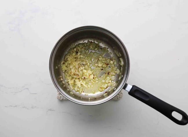 Sauteing onion and garlic in a pan.