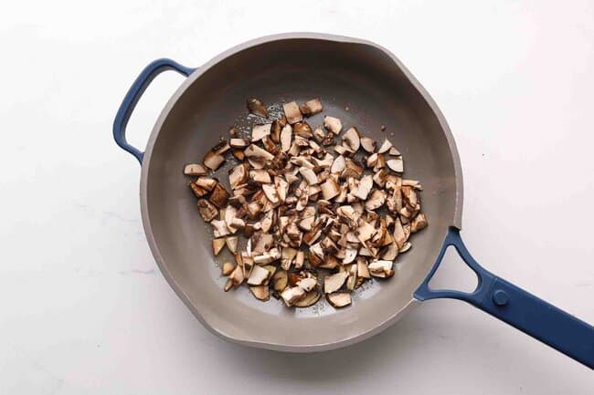Sauteing mushrooms in a pan.