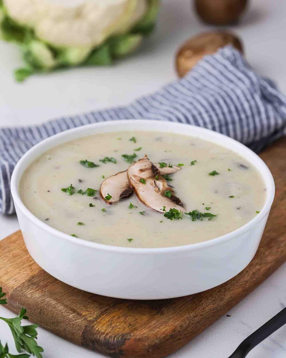 Creamy soup in a bowl with sliced mushrooms on top.